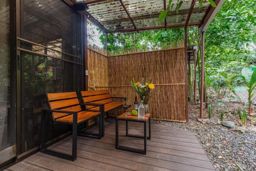 a patio with two benches and a table with flowers at TERMINAL VERDE PRIVATE APARTMENTS NEAR AIRPORT 24h SELF CHECK IN in Concepción