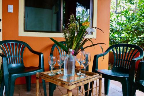 a table with wine glasses and a vase with flowers on it at TERMINAL VERDE PRIVATE APARTMENTS NEAR AIRPORT 24h SELF CHECK IN in Concepción