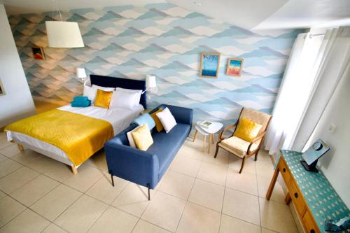 um quarto com uma cama e uma cadeira azul em O Trois Oliviers em Louin