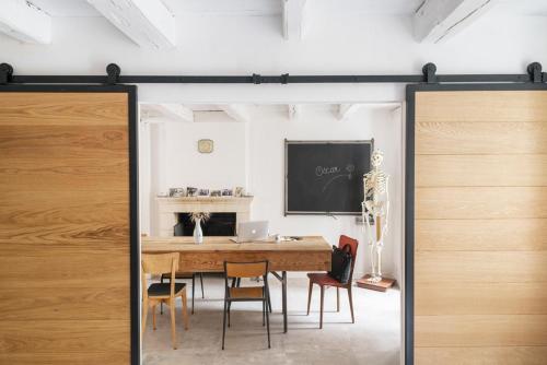 ein Esszimmer mit einem Holztisch und Stühlen in der Unterkunft Maison atypique au sein du joli village de Trentemoult in Rezé