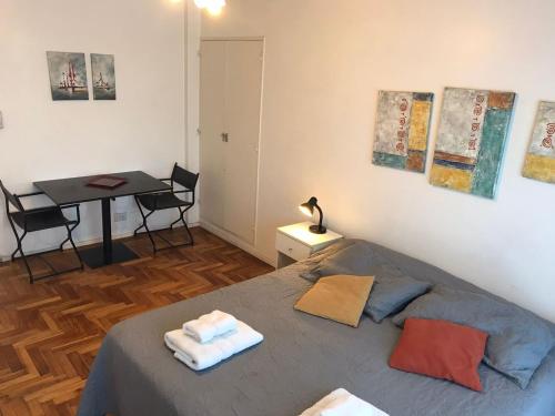 a bedroom with a bed and a table with chairs at Departamento en Recoleta muy luminoso Piso 10 in Buenos Aires