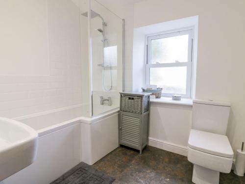 a white bathroom with a sink and a toilet at Hocking Cottage in Torquay
