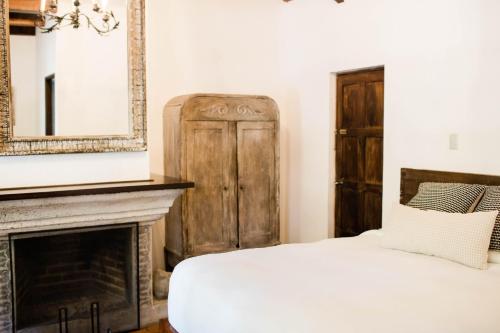 a bedroom with a bed and a fireplace at Casi Casa in Antigua Guatemala