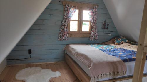 a bedroom with a bed with blue walls and a window at Skotopaska & Bukolika in Idzbark