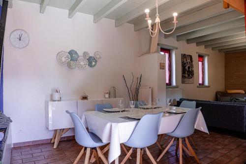 comedor con mesa blanca y sillas en Gite Les Volets Rouges, en Andres