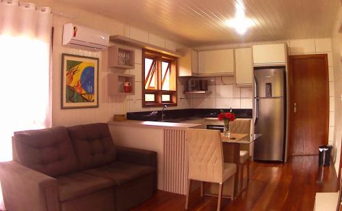 een keuken en een woonkamer met een bank en een tafel bij Cabana das Montanhas in Caxias do Sul