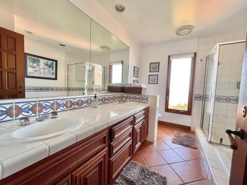 a bathroom with a sink and a large mirror at Sunrise Bliss Villa in Avalon