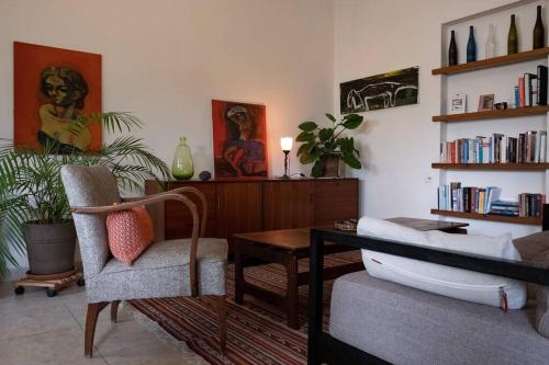 CHARMING APARTMENT AT UNBEATABLE SPOT في تل أبيب: غرفة معيشة مع مكتب وكرسي
