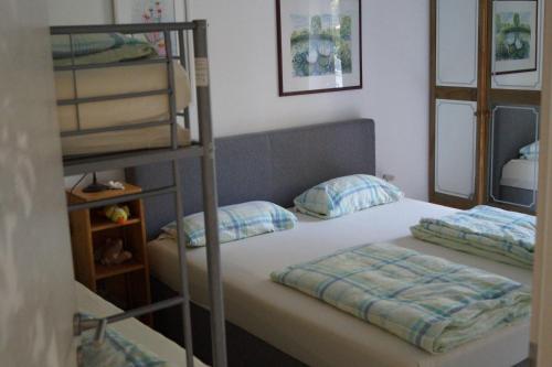 Ferienwohnung Birkenried في Reisensburg: غرفة نوم مع سرير بطابقين مع وسادتين