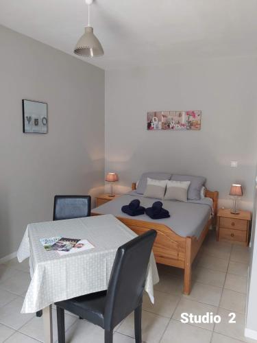 une chambre avec un lit, une table et des chaises dans l'établissement Appartements Danciu, à Jonzac