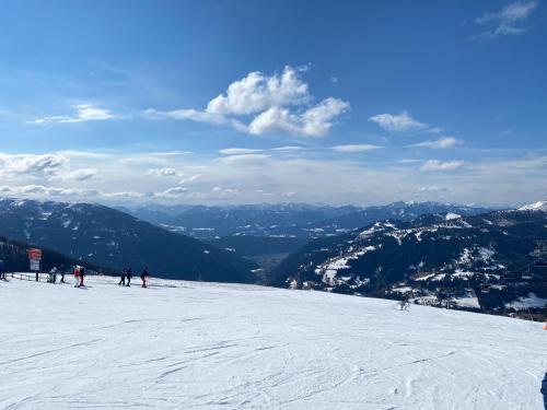 a group of people skiing down a snow covered mountain at Appartement Rosa in Patergassen