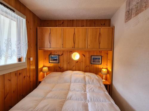 sypialnia z łóżkiem, drewnianymi ścianami i oknem w obiekcie Charmant appartement 3 pièces, terrasse, ski à proximité - FR-1-425-135 w mieście Flaine