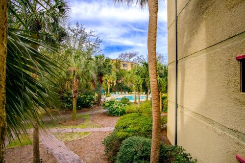 a view of a garden with palm trees and a pool at Xanadu in Hilton Head Island