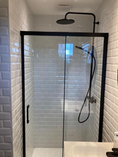 une douche avec une porte vitrée dans une salle de bain dans l'établissement Villa Sagrada l'Atelier ****, à Toulouse