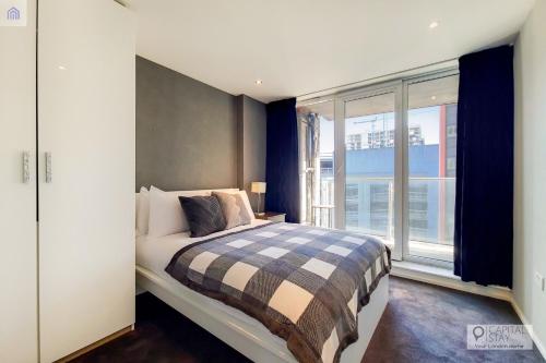 ロンドンにあるTwo Bedroom Apartment - London ExCeL Staysのベッドルーム1室(ベッド1台、大きな窓付)
