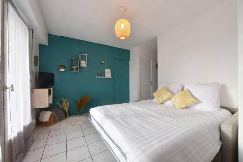 - une chambre avec un grand lit et un mur bleu dans l'établissement Cabana & Le Central - Proche Lac , Terrasse et Parking, à Annecy