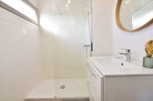 La salle de bains blanche est pourvue d'une douche et d'un lavabo. dans l'établissement Cabana & Le Central - Proche Lac , Terrasse et Parking, à Annecy