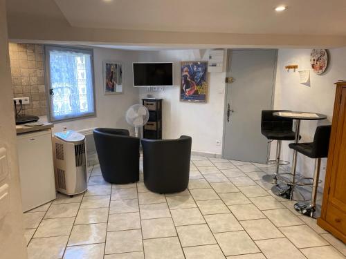 バルジュモンにあるLa Dolce Vita climatisation animal interditのキッチン(椅子、テレビ付)が備わる客室です。