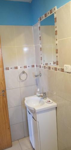 a white bathroom with a sink and a mirror at Shabat in Ushuaia