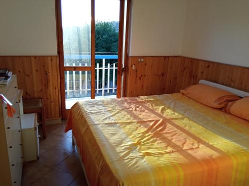 um quarto com uma cama e uma grande janela em Casa Trentova em Agropoli