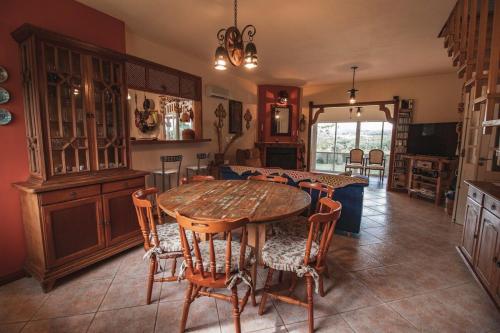 a dining room with a wooden table and chairs at Casa Fuchsia Régia em Rancho Queimado/SC in Rancho Queimado