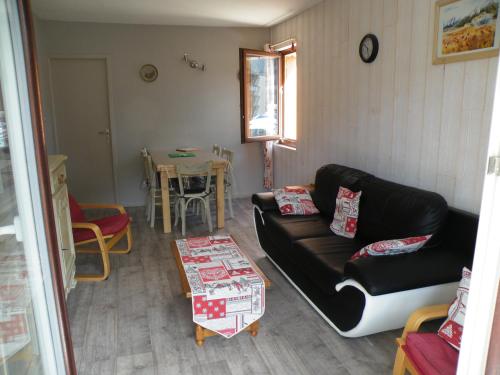 un salon avec un canapé et une table dans l'établissement Appartement a la montagne ,vue sur les pistes, à La Bresse