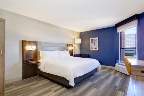 um quarto de hotel com uma cama e uma janela em Holiday Inn Express & Suites Phoenix - Tempe, an IHG Hotel em Tempe