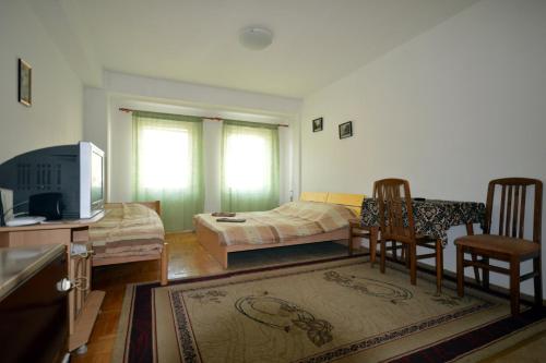 uma sala de estar com uma cama, uma mesa e cadeiras em Apartment NAUM M em Ohrid