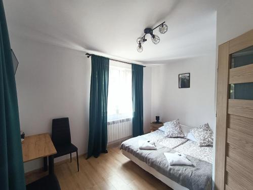 a bedroom with a bed and a desk and a window at Pokoje za Basztą in Kazimierz Dolny