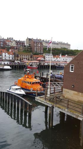 an orange boat is docked next to a dock at Arundel House in Whitby
