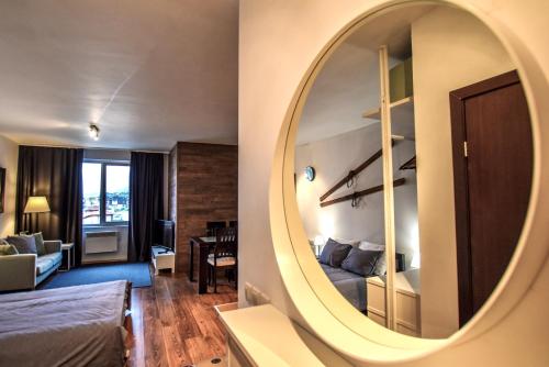 a room with a mirror and a living room at Bansko Royal Towers Apartments - Gondola View in Bansko