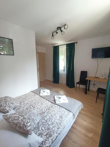 um quarto com uma cama, cortinas verdes e uma mesa em Pokoje za Basztą em Kazimierz Dolny