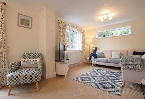 ein Wohnzimmer mit einem Sofa und einem TV in der Unterkunft St Keyne - A Hidden Gem Nestled in Shaldon in Shaldon