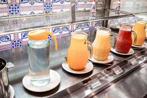 a row of pitchers of different types of drinks at Cannes Palace Hotel in Vitória