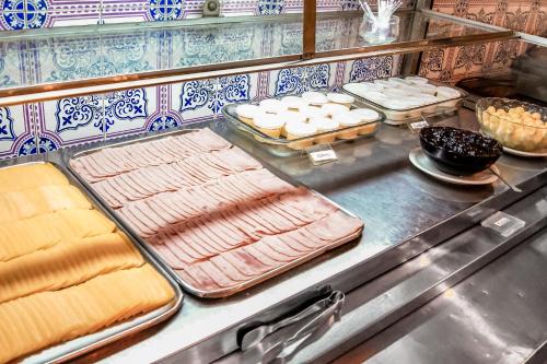 a kitchen with several trays of food on a counter at Cannes Palace Hotel in Vitória