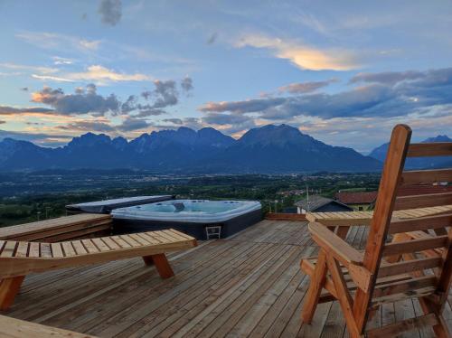 a hot tub sitting on a wooden deck with a bench at Casa dei Moch in Belluno