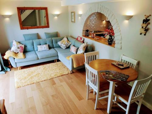 a living room with a blue couch and a table at Hidden gem on the edge of the Cotswolds in Charfield