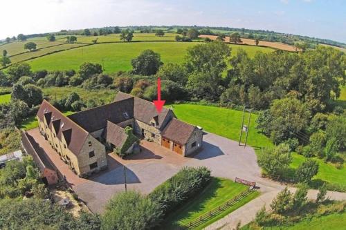 an aerial view of a house in a field at Hidden gem on the edge of the Cotswolds in Charfield