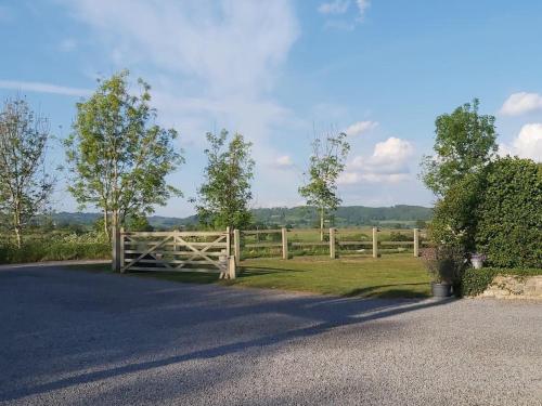 a wooden fence in front of a field at Hidden gem on the edge of the Cotswolds in Charfield