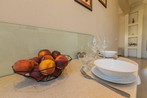 a bowl of fruit sitting on a table with glasses at Однокімнатні апартаменти на Майдані, дистанційне заселення 24х7 in Kyiv