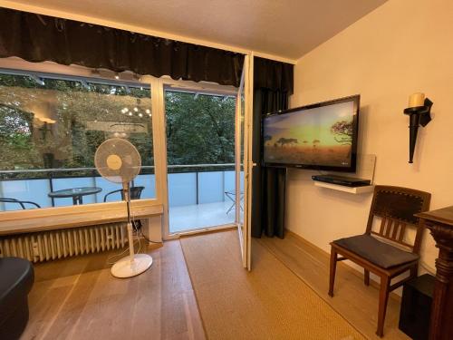 uma sala de estar com uma grande janela e uma televisão de ecrã plano em Apartment am Roten Tor em Augsburg