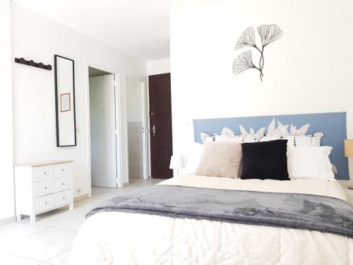 - une chambre blanche avec un grand lit et un mur bleu dans l'établissement Studio au calme, proche commerces et plages, à Antibes