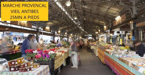 un marché avec des gens qui traversent un marché agricole dans l'établissement Studio au calme, proche commerces et plages, à Antibes