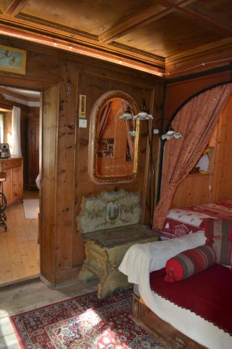 a bedroom with a bed and a mirror at B&B La Tana dell'Orso - Die Bärenhöhle in Castello di Fiemme