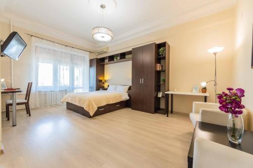 a bedroom with a bed and a table and a couch at Однокімнатні апартаменти на Майдані, дистанційне заселення 24х7 in Kyiv