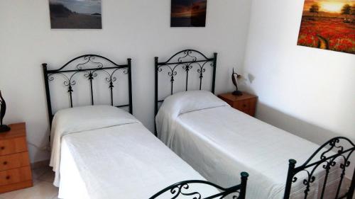 two twin beds in a room with white walls at Casa Maria Russo in Casal Velino