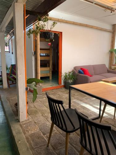 sala de estar con mesa, sillas y sofá en Chirris Hostel, en San Juan La Laguna