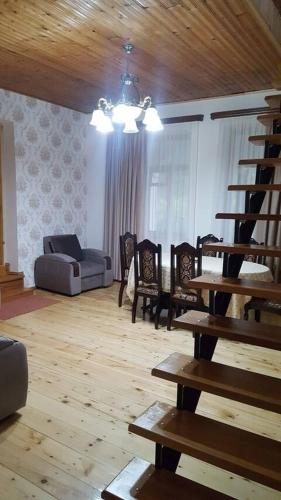 a living room with a staircase and chairs and a couch at Nairi Guest House in Stepantsminda