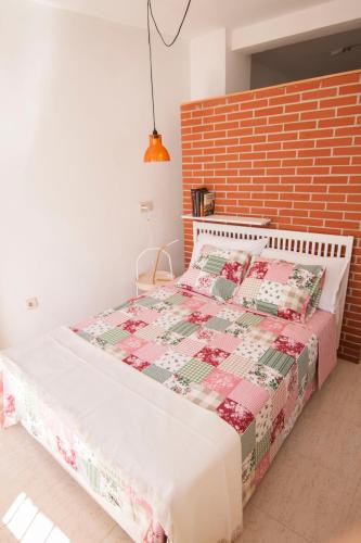 a bedroom with a bed and a brick wall at Cozy house near to the city center of Granada in Granada