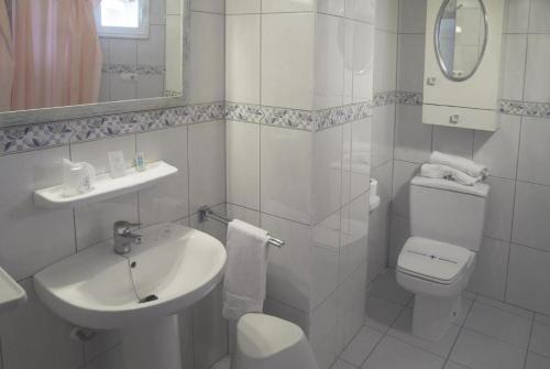 a white bathroom with a sink and a toilet at Chinasol Suites in Almuñécar